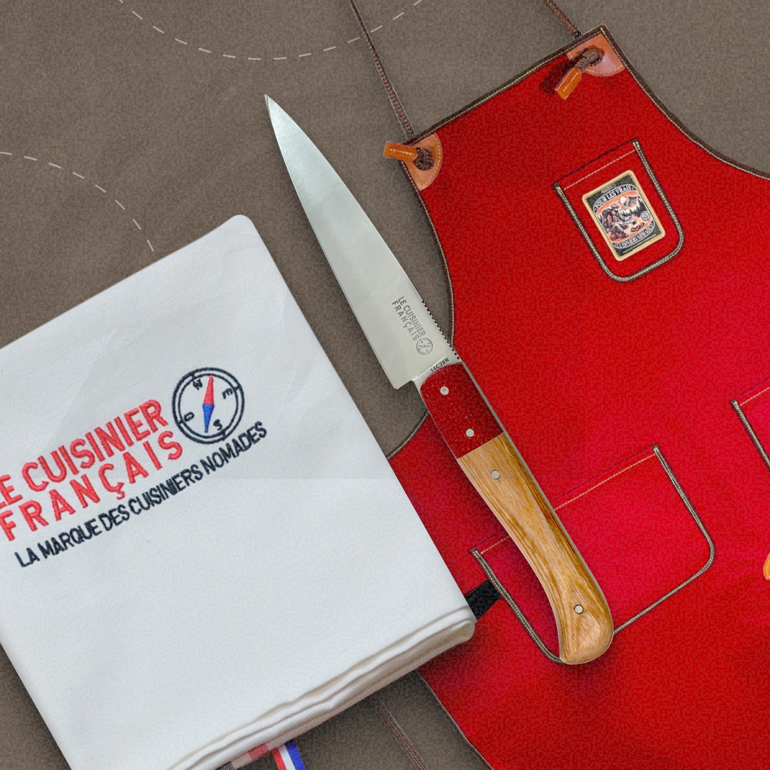 Pack BBQ Le Cuisinier Français : Tablier rouge signature, torchon brodé et couteau Esperluète, le kit idéal pour les grillades.